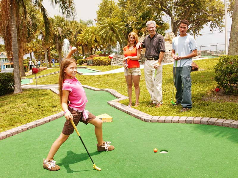 Family playing mini golf