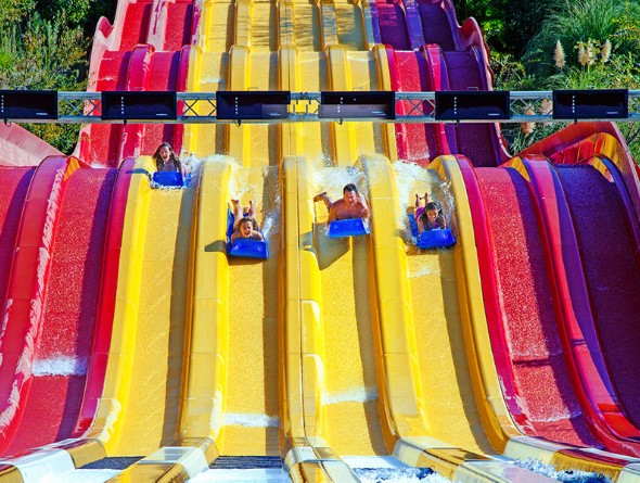People racing down a water slide